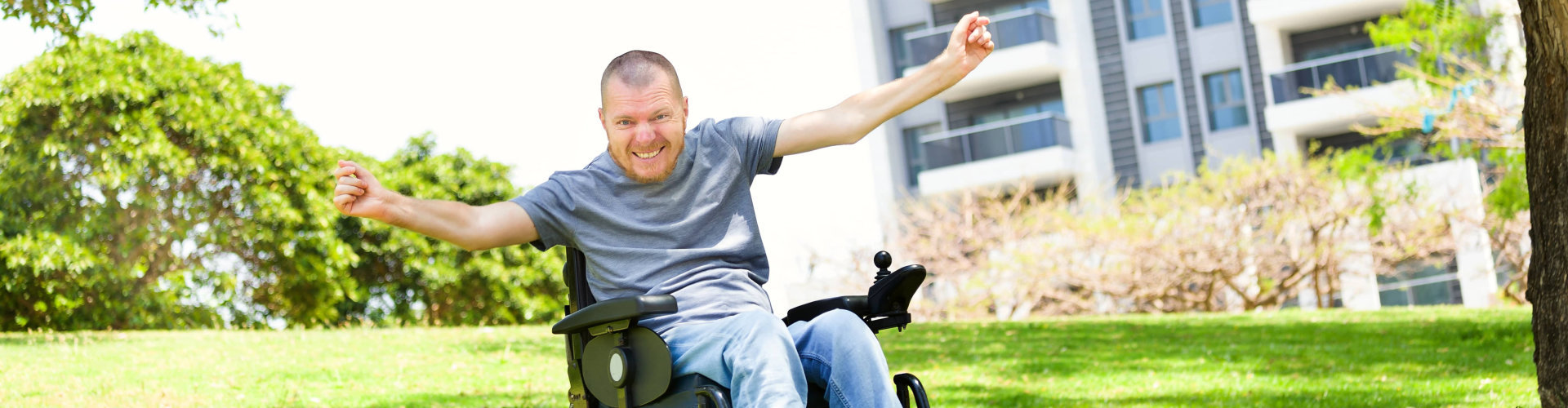 Disabled man in a wheelchair enjoying fresh air at the park